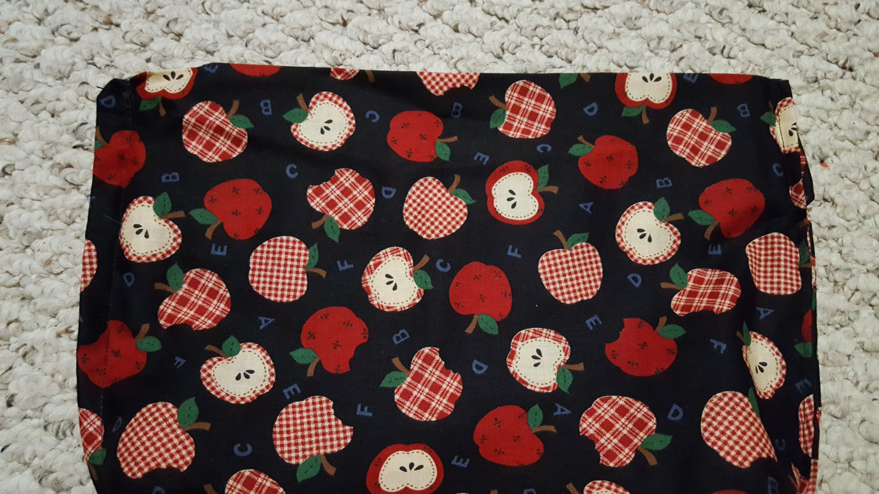 apple fabric layed out to make a microwavable popcorn bag