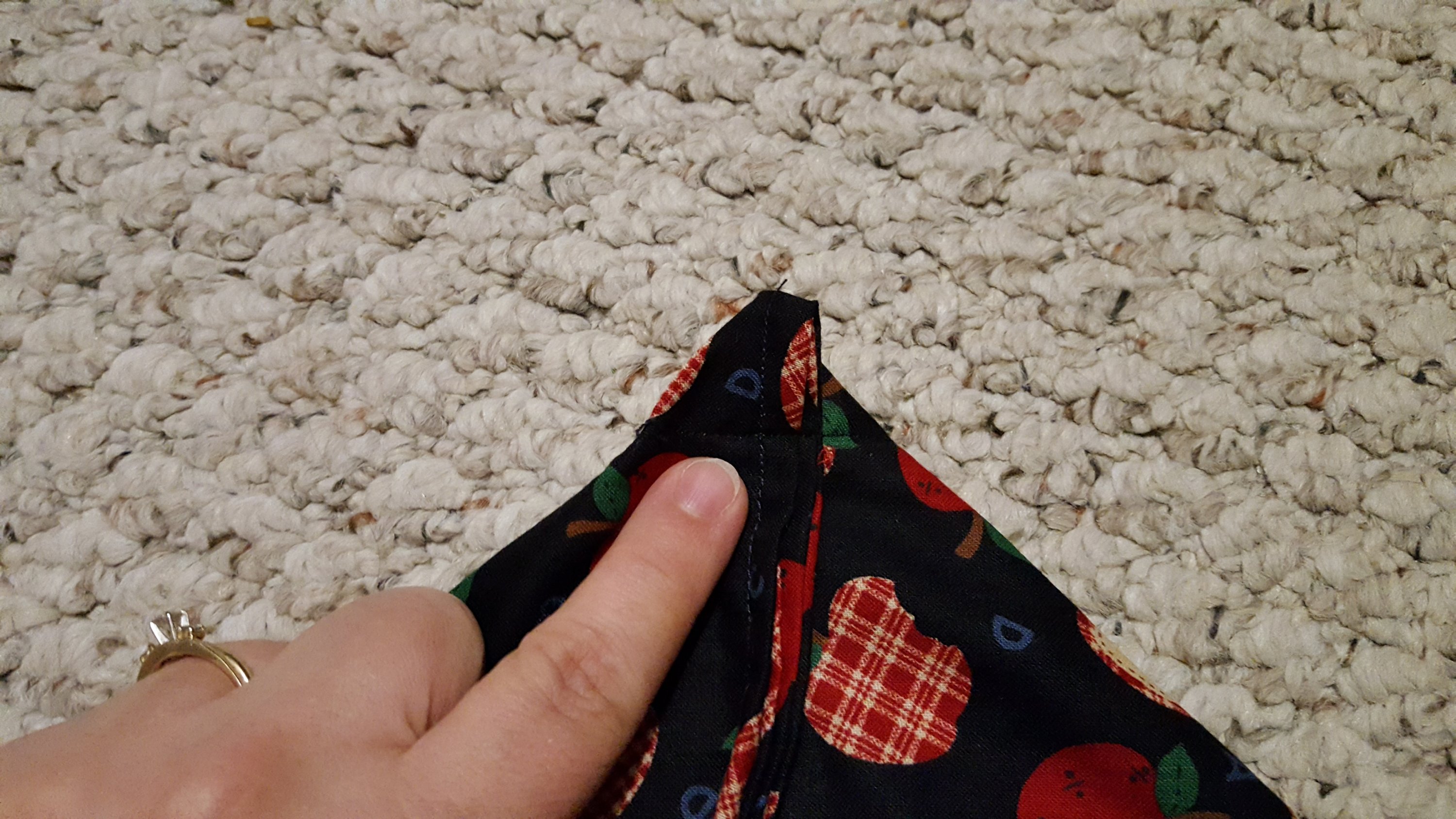 woman's finger pointing to the corner of a microwave popcorn bag ready to sew
