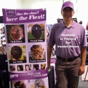 Lilla Rose Hair Accessories product review image LoveLeavingLegacy team member at a trade show with banner of Flexi Clip Husband In Training for vendor shows