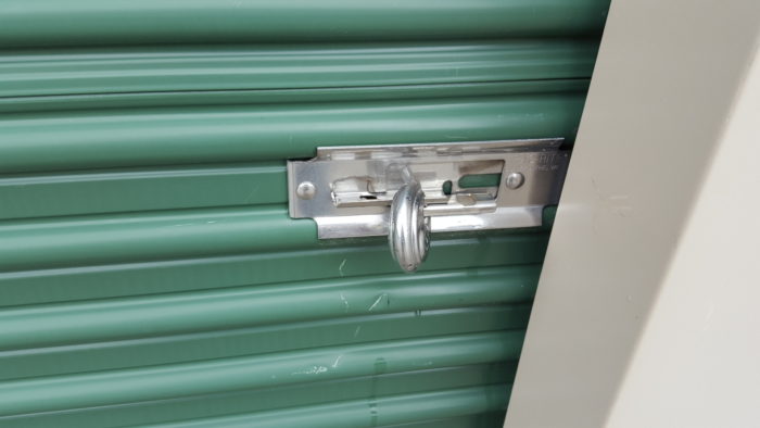 a circle lock on a storage unit but the door is unlocked because the metal slider was not slid to the right How To Keep Your Storage Unit Items Safe