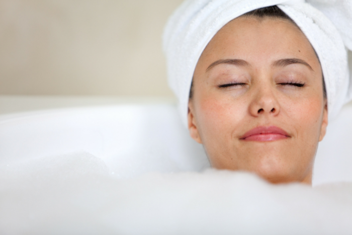 woman with towel turban relaxing in bubble bath Designing the Ultimate Luxurious Bathroom