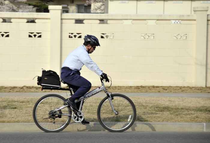 man riding his bike to work with helmet risks to avoid when you plan your saving strategy
