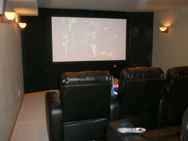 home theater room theater seating in a home with big screen and side lights
