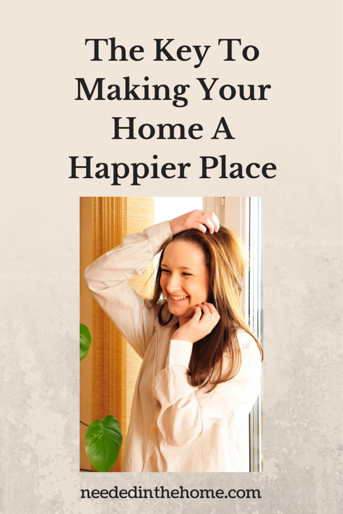 smiling woman in front of window in her home The Key To Making Your Home A Happier Place 