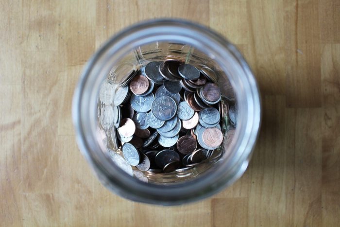 coins in a jar top view Simple Ways To Save Money Around The Home 