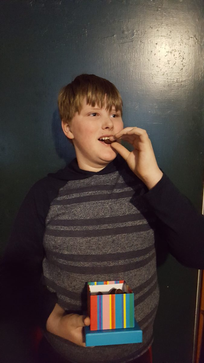 a boy trying chocolate-covered mini sandwich cookies from Dylan's Candy Bar Chocolate Sweet Treat Tower