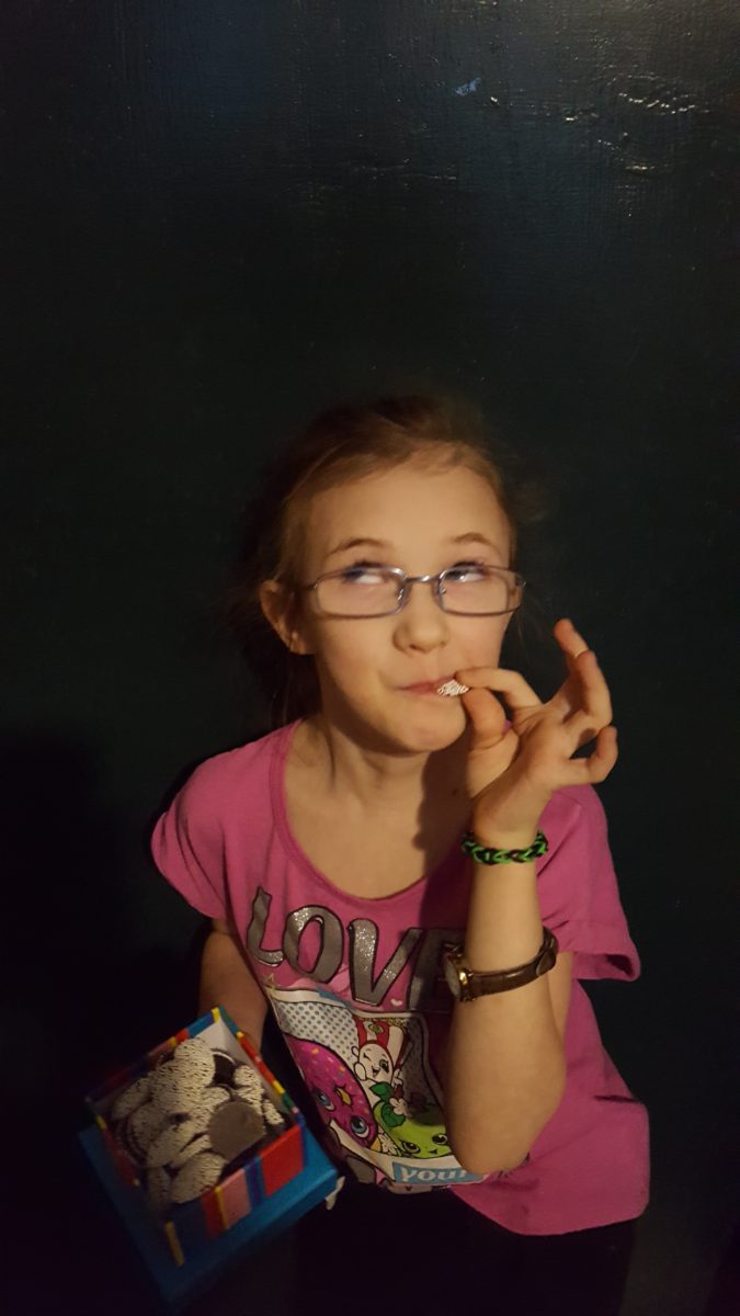 a young girl in glasses trying dark chocolate nonpareils from Dylan's Candy Bar Chocolate Sweet Treat Tower