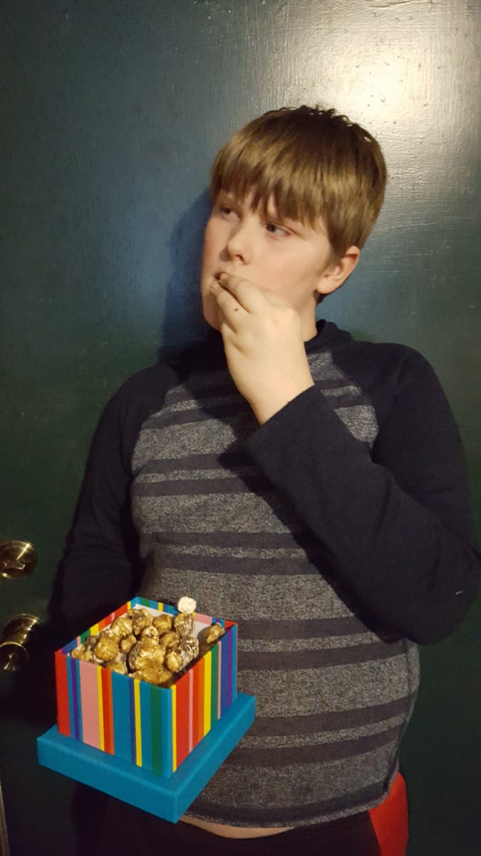 A teen boy tasting S'mores Popcorn from Dylan's Candy Bar Chocolate Sweet Treat Chocolate Tower
