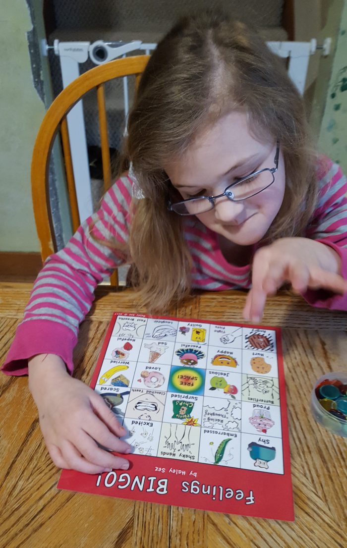 a young girl in glasses playing bingo