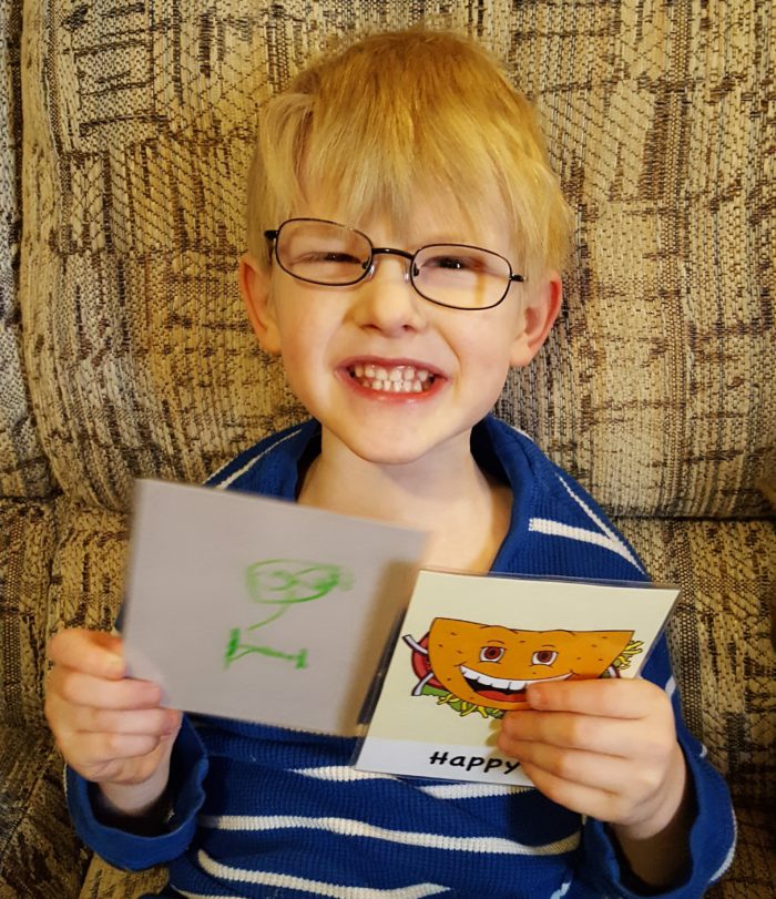 boy in glasses with big smile demonstrating happy and showing his art of happy