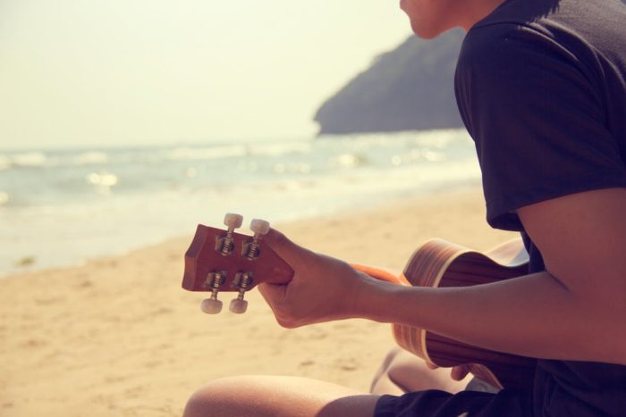 Learning to play the ukulele on the beach