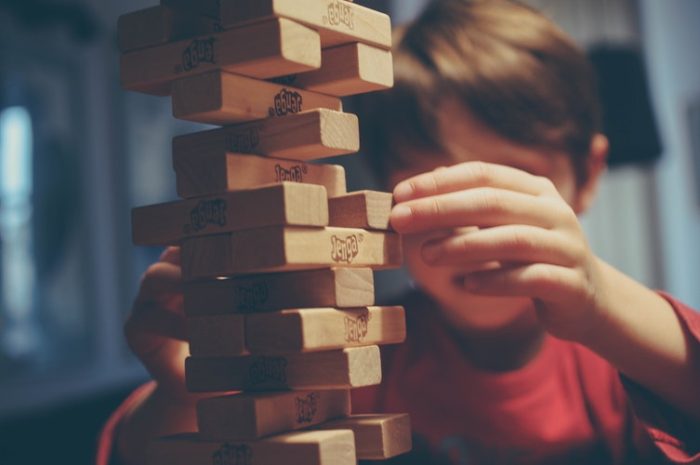 boy playing jenga game building a home that lasts