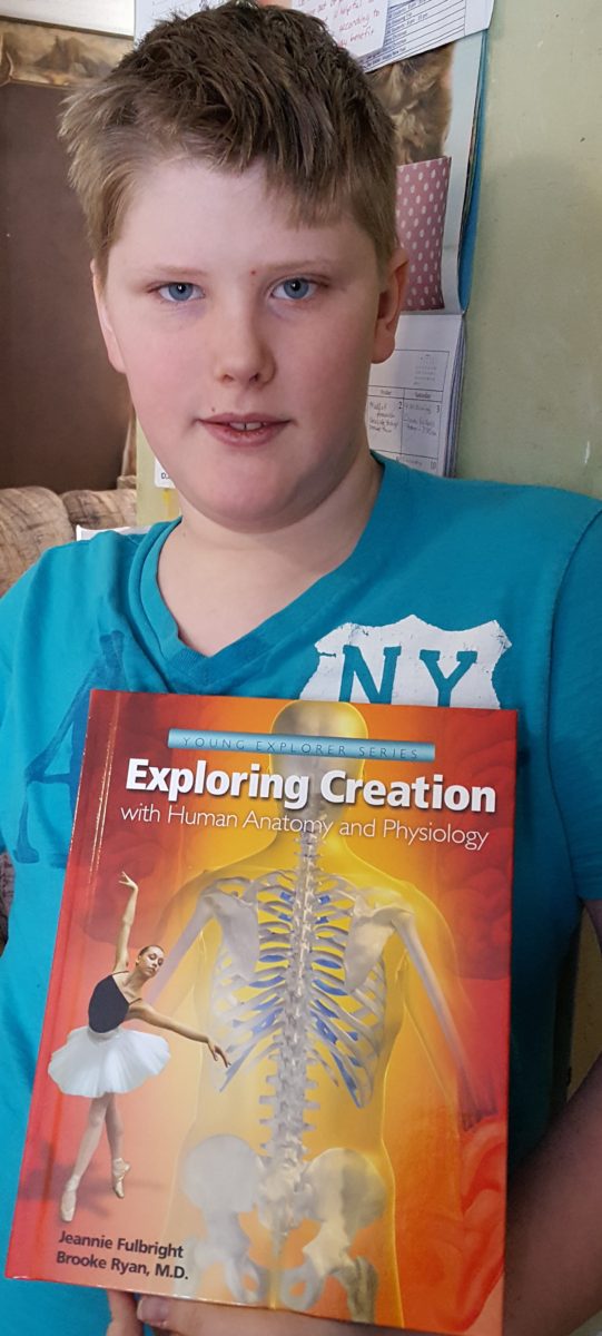 Review of Exploring Creation with Human Anatomy and Physiology 6th grade boy holding textbook