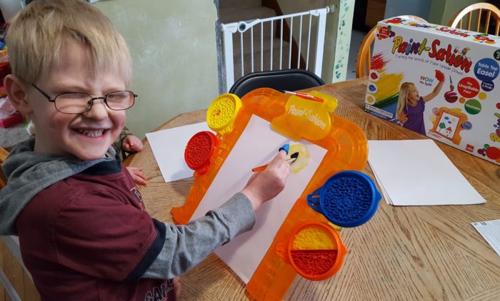 review of Paint-Sation young boy is painting on his easel