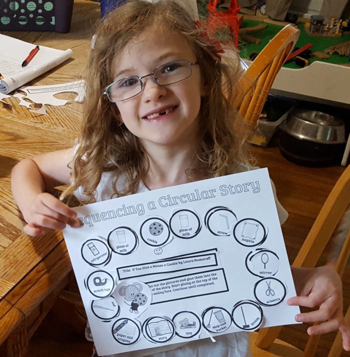 Home School Navigator image young girl in glasses shows her completed worksheet for Level Red