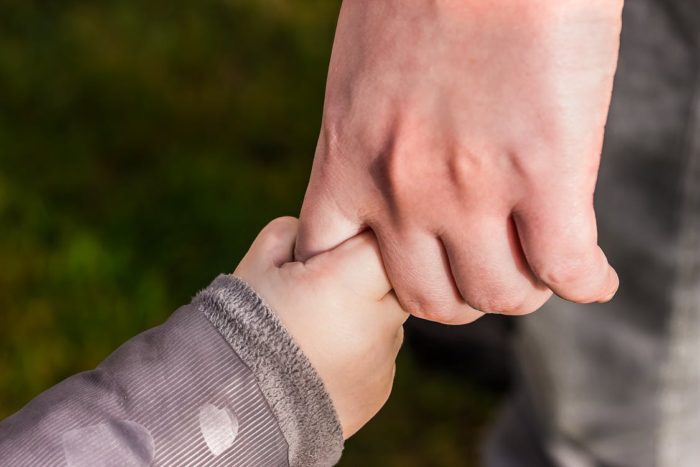 Skills your teens will need in life image parent holding toddler's hand