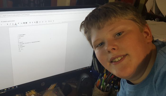 Code for teens review a teen boy near the computer screen with answers to quiz on coding