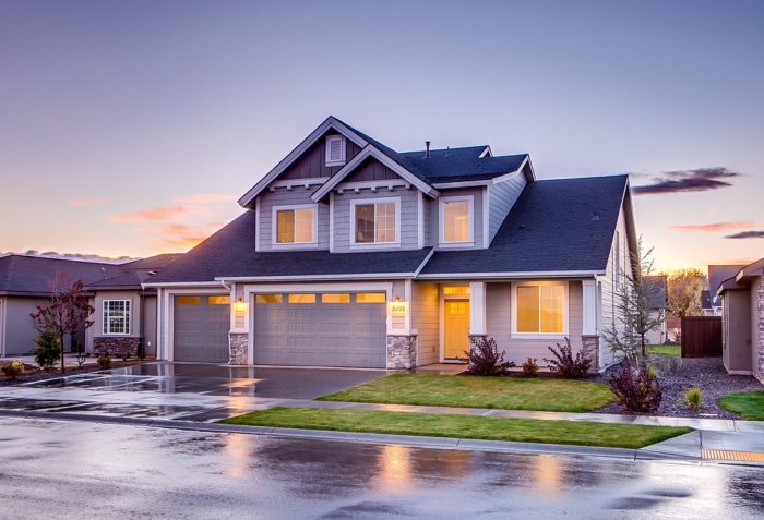 Improving curb appeal on a budget home with lighting in the early evening wet streets