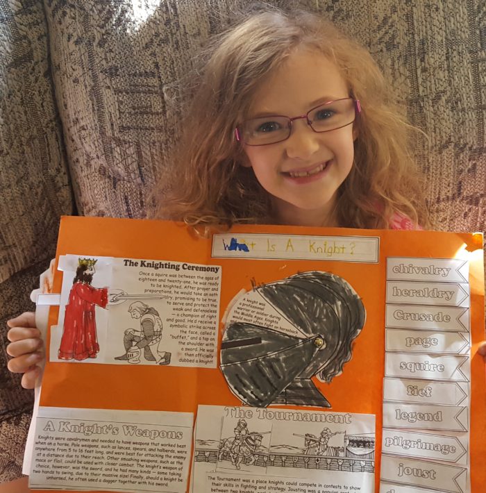 Girl proudly showing her Knights lap-pak from Homeschool In The Woods Publishing