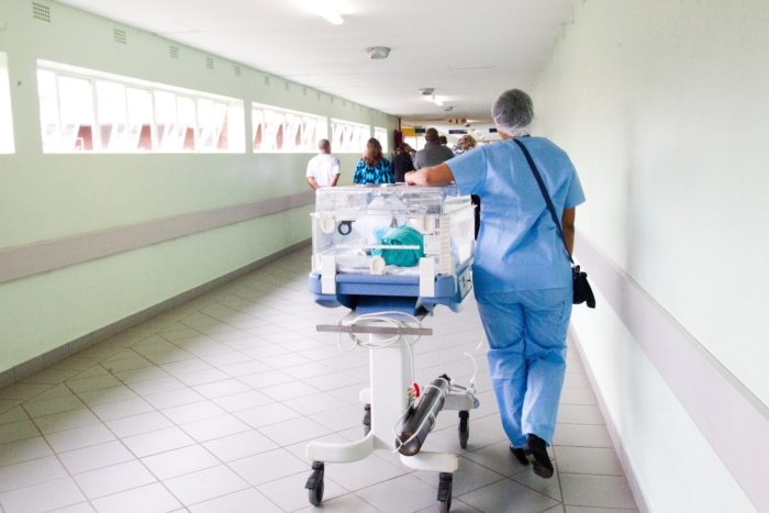 Careers that help you give back nurse walking with NICU patient in hallway 