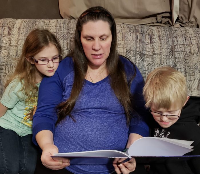 Psalm 136 book review pregnant mother reads to her young daughter and son on couch from a Christian picture book