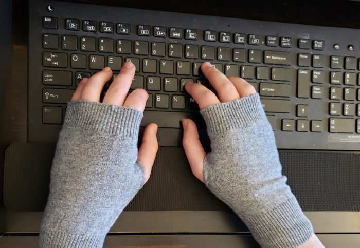Cashmere writing gloves worn by teen girl typing on black keyboard heather gray color yarn