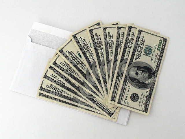 Finances in times of trouble open envelope cash dollars money hundred dollar bills