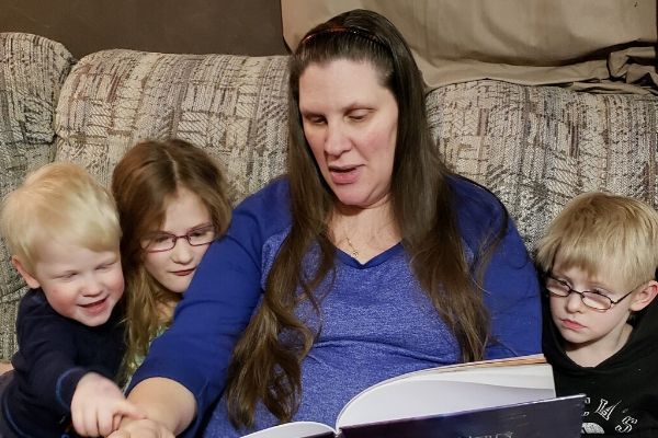 A mom with her three children reading stories