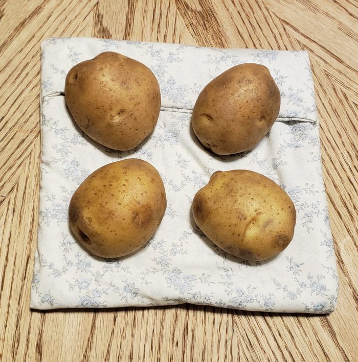 Reusable microwave potato bag with four potatoes made of cotton floral fabric