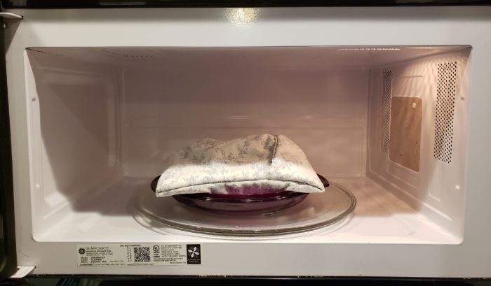 Microwave potato bag in the microwave ready to start cooking four steam cooked potatoes