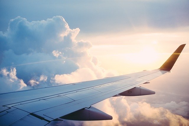 wing of airplane against clouded sky