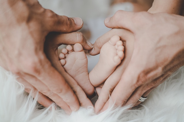 things you need to do as a parent dad and moms hands holding babys feet