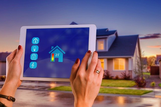 smart technology home hands holding tablet outside front of home screen shows temperature control