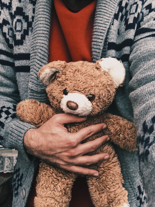 mother holding teddy bear grieving loss of a child