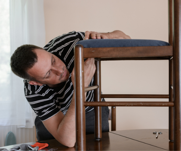 man adding modern touch to home by reupholstering a chair with velvet blue fabric