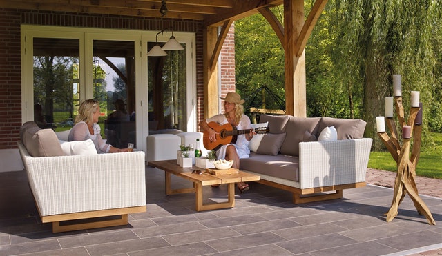 your outdoor space extended family room couches on covered porch with two women and guitar