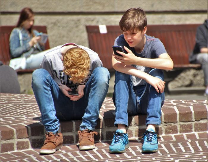 teen social skills two boys playing pokemon go on their smartphones