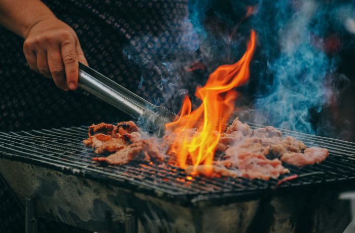 perfect outdoor party barbecue person holding tongs moving meat on flame