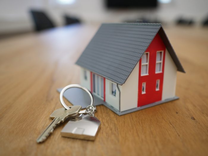 selling your home tiny toy house next to house key on keychain ring