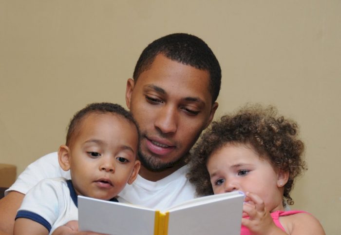 dad reading book to his two small children