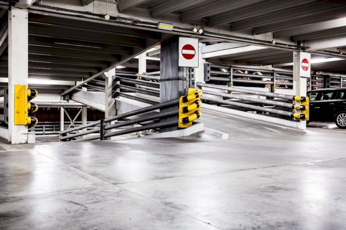 building steel parking interior view ramp to next level with bumpers and signage