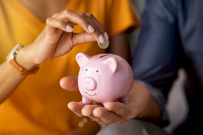 financial stability big families putting coin into piggy bank