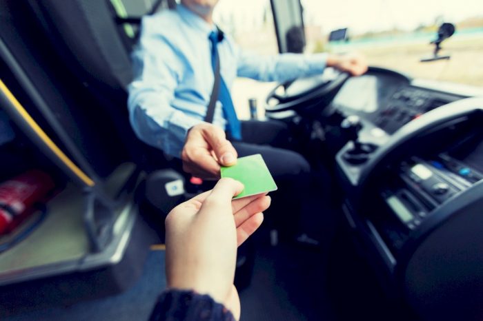 save money studying abroad hand giving bus pass to bus driver