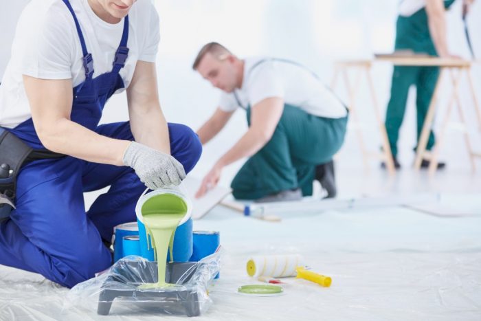 increasing efficiency when renovating men in overalls and white shirts preparing to paint a room green