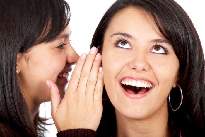 your company more visible woman telling a secret to another woman who looks surprised and happy