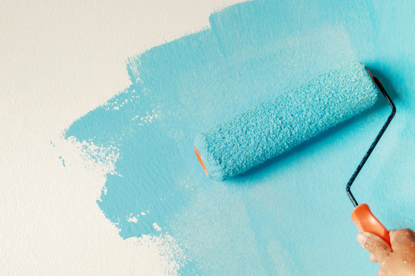 non toxic paint for home in light blue being rolled onto white wall with roller