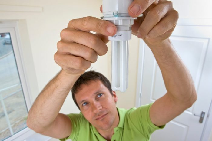 man adding new light bulb to brighten gloomy spaces in the house