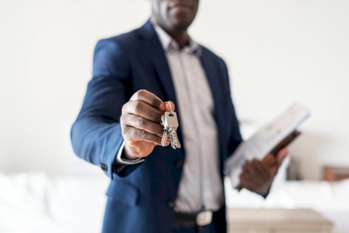 real estate agent holding keys and paperwork when buying home overseas