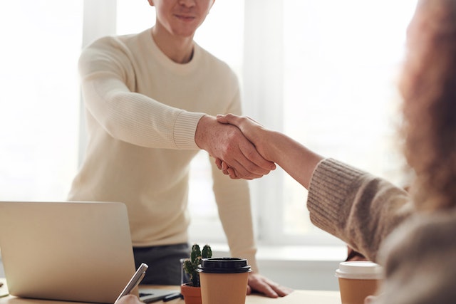 standing man shaking sitting woman's hand for job interview after start seeking another job