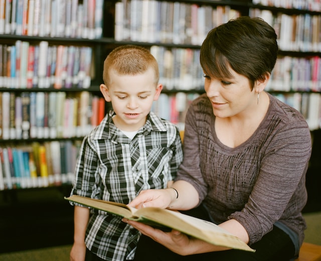 improving homeschool techniques mom and son looking at a book in the library
